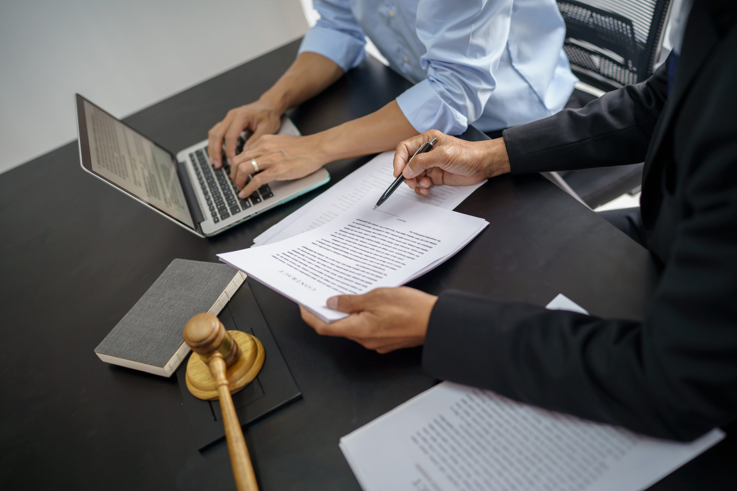 Avocat et dirigeant examinant des documents juridiques relatifs à une procédure disciplinaire ou à une rupture de contrat.