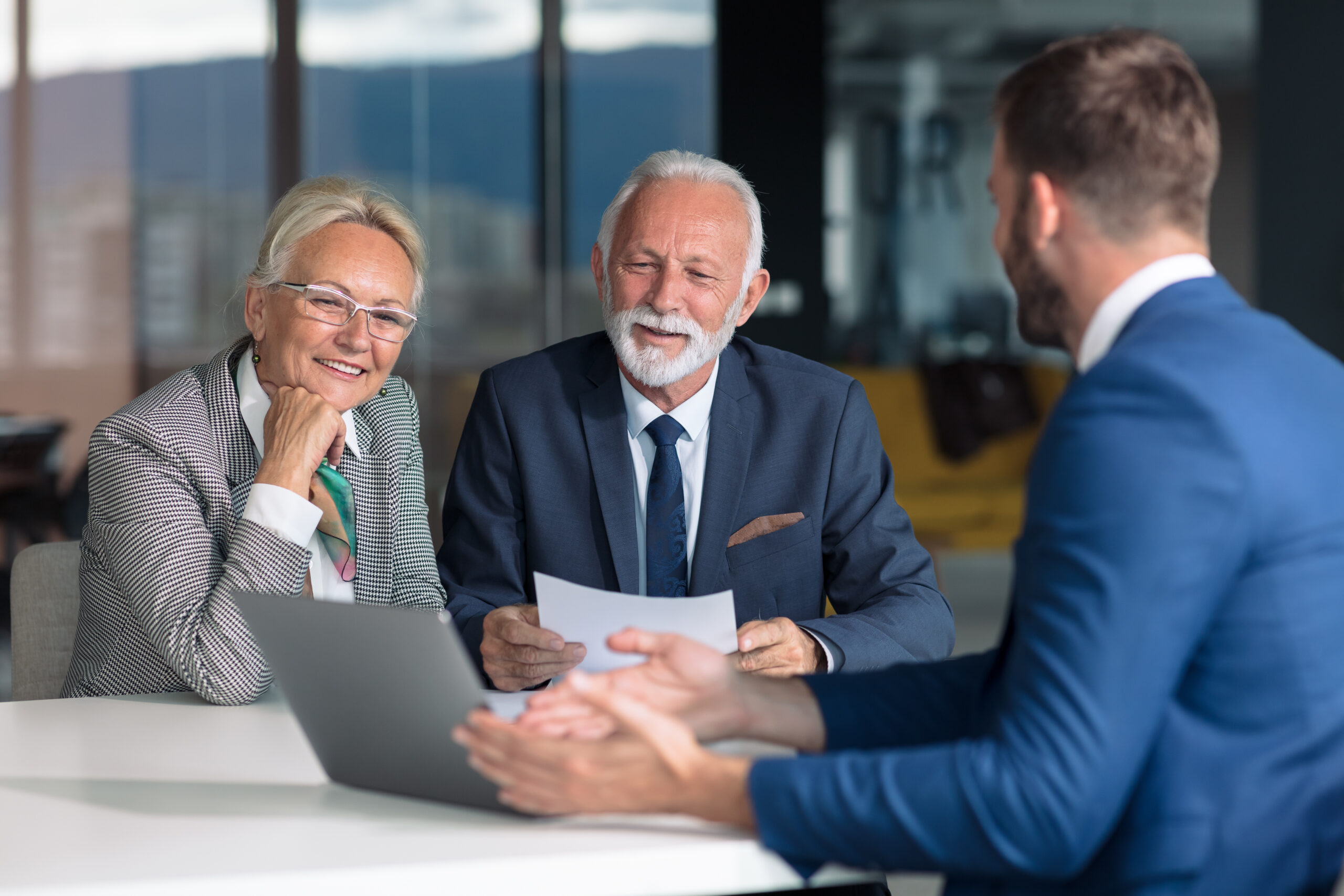 Couple de seniors échangeant avec un conseiller pour réaliser un diagnostic patrimonial et préparer leur stratégie de transmission.